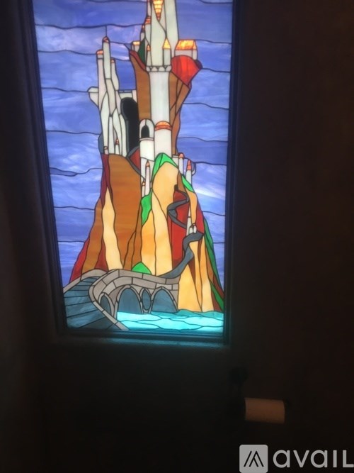 A stained glass window depicting a castle on a cliff.