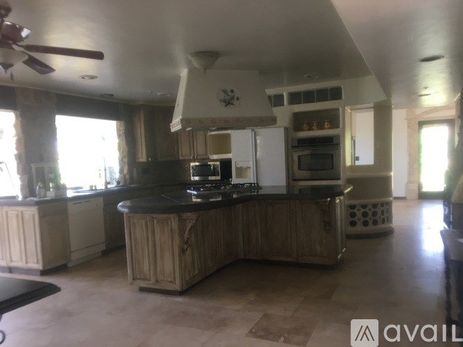 A kitchen with a large island and a fan.