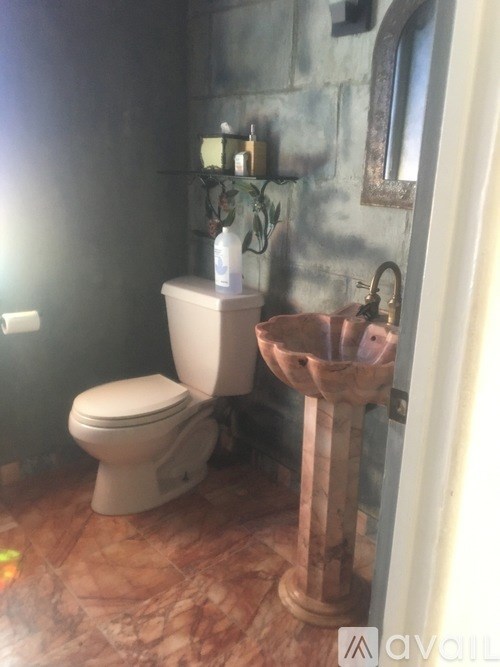 A bathroom with a toilet, a sink and a mirror.
