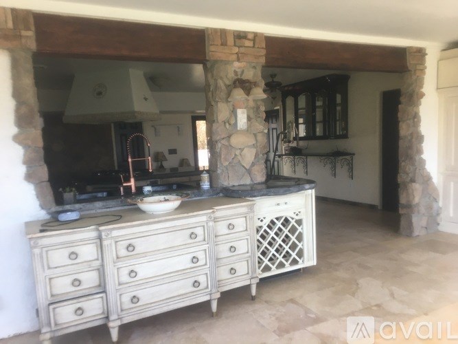 A kitchen with a stone pillar and a stone fireplace.