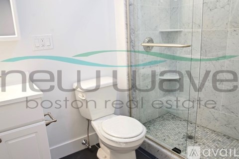 A white toilet in a bathroom with a glass shower door.