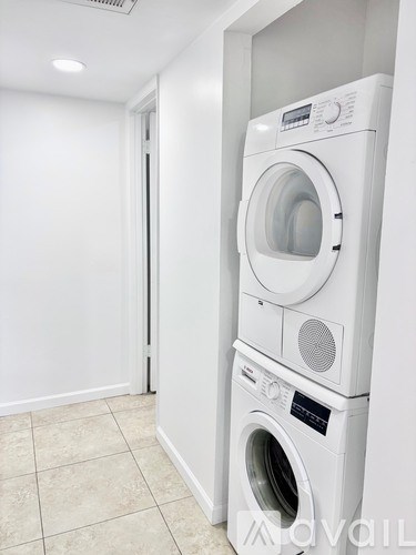 A white washing machine and dryer in a laundry room.