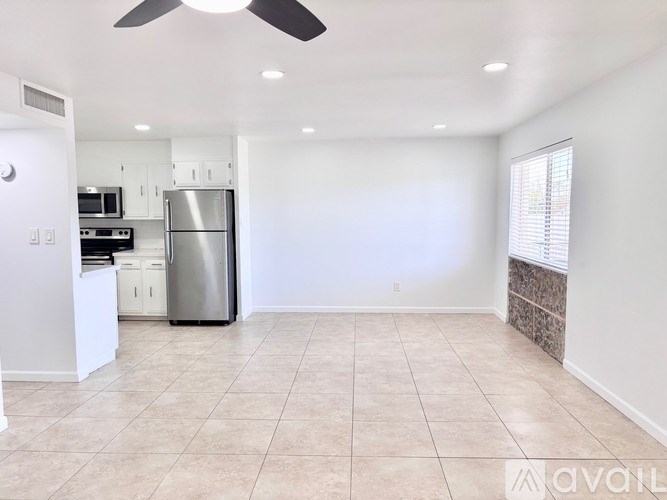 A kitchen with a refrigerator, microwave, and oven.