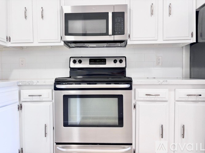 A modern kitchen with a stove, oven, microwave, and cabinets.