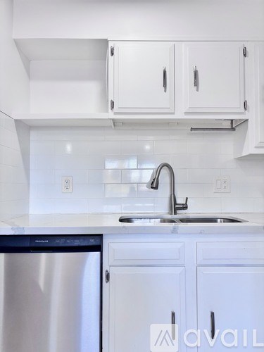 A kitchen with white cabinets and a stainless steel dishwasher.