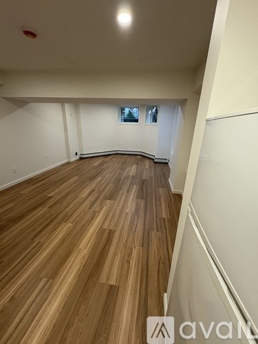 A room with wooden flooring and white walls.