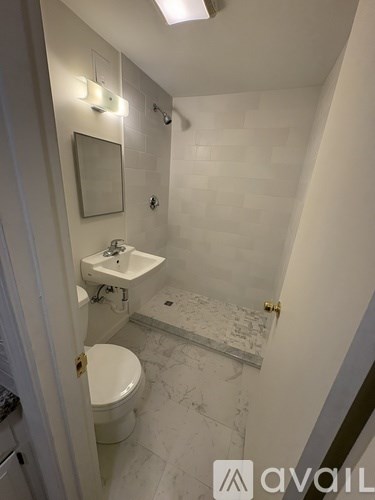 A bathroom with a toilet, sink, and mirror.