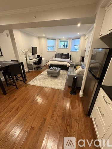 A well-lit, spacious kitchen and living room with hardwood floors and modern appliances.