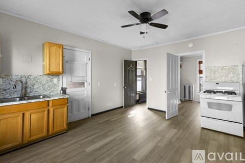 A kitchen with wooden cabinets and a marble backsplash.