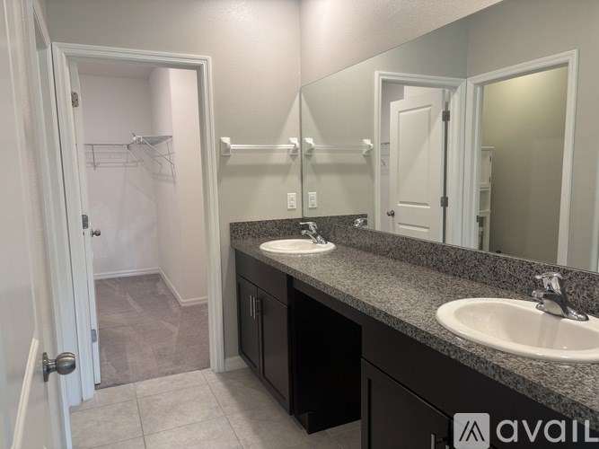 A bathroom with a sink, mirror, and a shower.