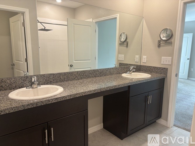 A bathroom with two sinks and a large mirror.