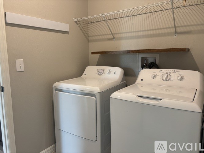 A small laundry room with a washer and dryer.