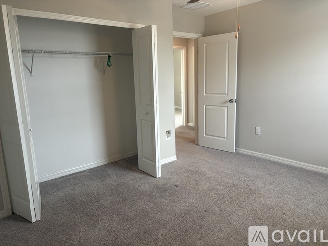 A room with a carpeted floor and two doors, one of which is open.