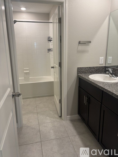 A bathroom with a sink, mirror, and shower.