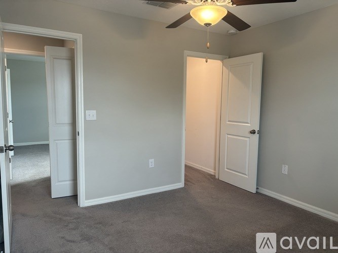 A room with a ceiling fan and two doors.