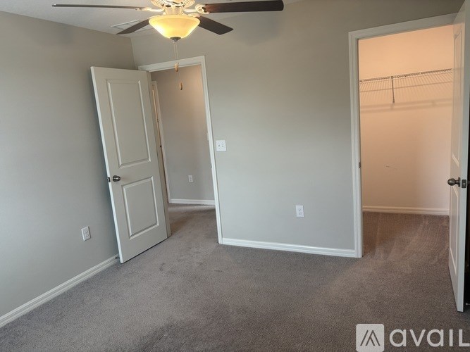 A room with a ceiling fan and three doors.