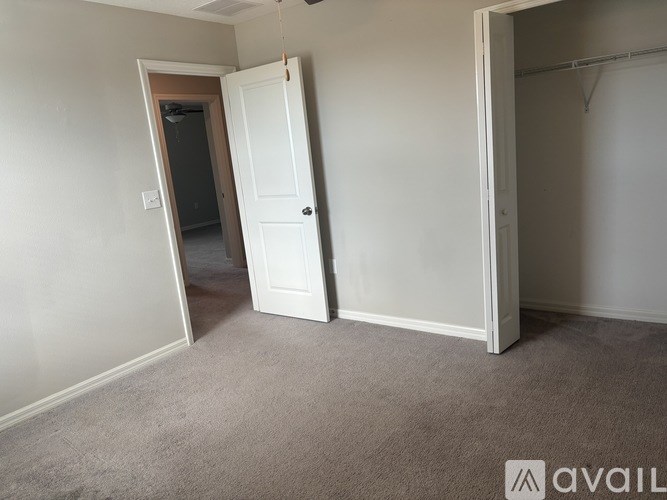 A room with a carpeted floor and two open doors.