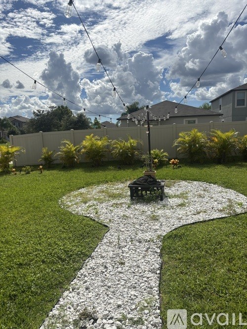 A garden with a white gravel path and a bird bath.