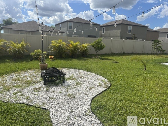 A garden with a gravel path and a small tree in a pot.