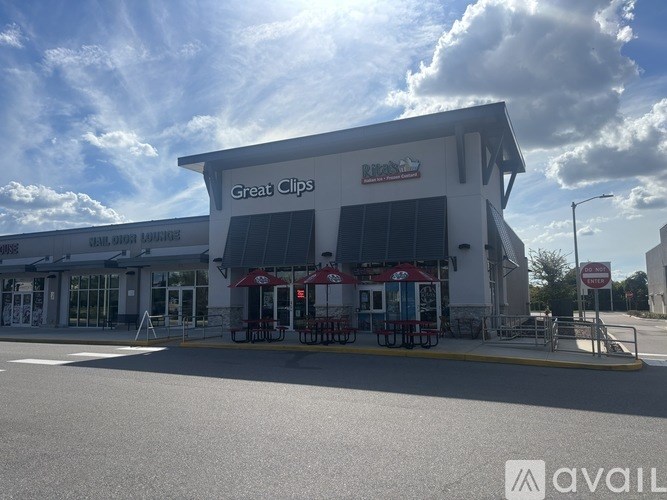 A Great Clips hair salon with a red awning and outdoor seating area.
