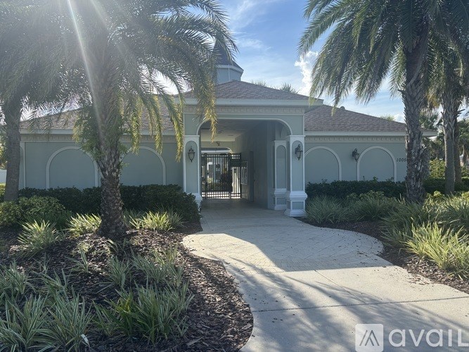 A house entrance with a pathway and a tree in front.