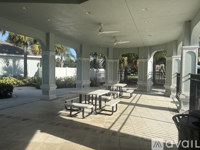 A covered patio with tables and benches.
