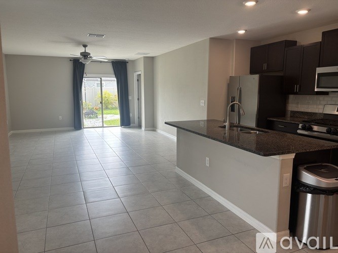A kitchen with a refrigerator, microwave, and oven.