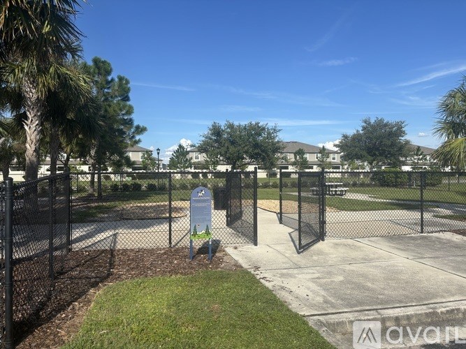 A park with a sign and a fence.