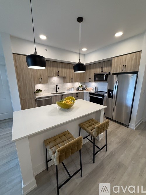 A modern kitchen with a white island and two stools.