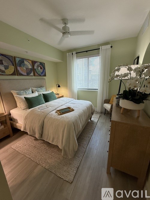 A bedroom with a bed, nightstand, and a ceiling fan.