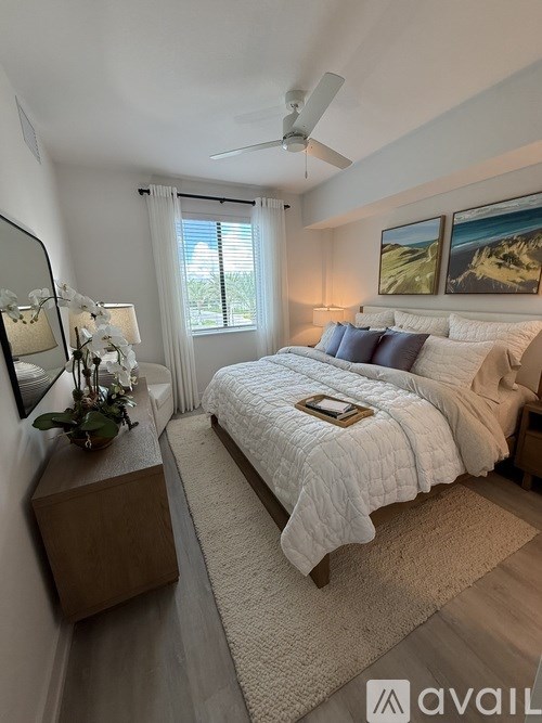 A bedroom with a large bed and a ceiling fan.