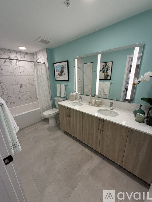 A bathroom with a toilet, sink, and mirror.