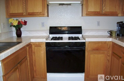 A kitchen with wooden cabinets and a black stove top oven.