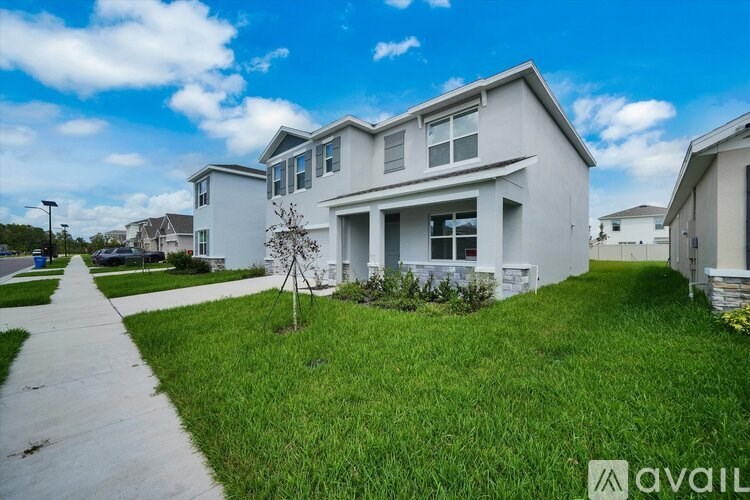 A modern house with a white exterior and a well-maintained lawn.