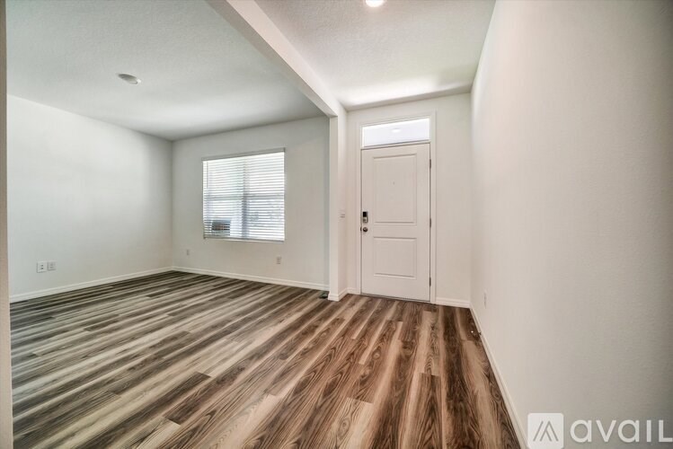 A room with wooden flooring and a white door.