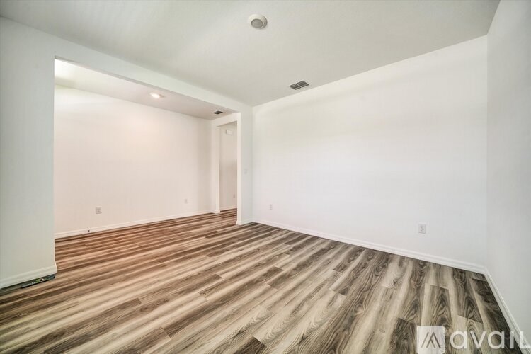 A room with wooden flooring and white walls.