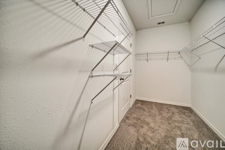 A room with a carpeted floor and a wall-mounted clothes drying rack.