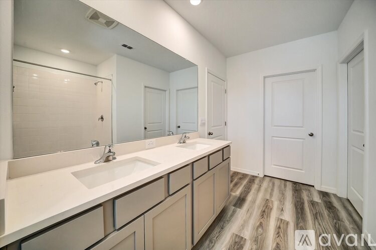 A bathroom with two sinks and a large mirror.