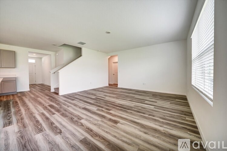 A room with wooden flooring and a white wall.