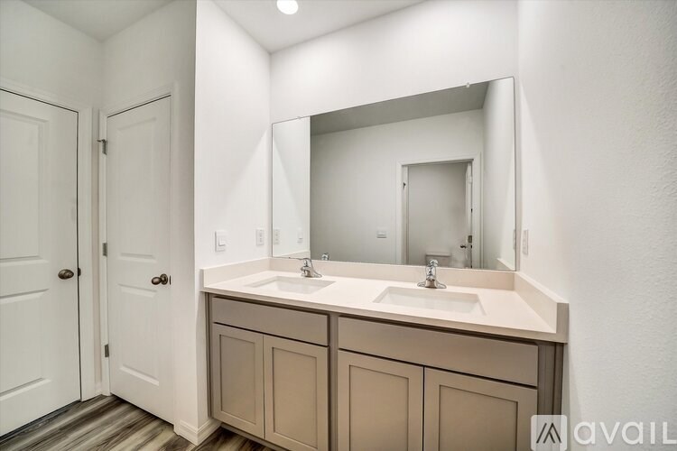 A bathroom with a double sink vanity and a large mirror.