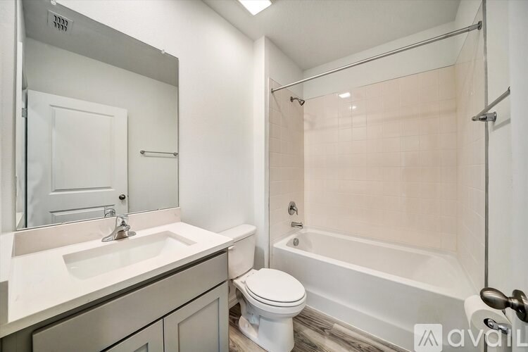 A bathroom with a white toilet, sink, and bathtub.