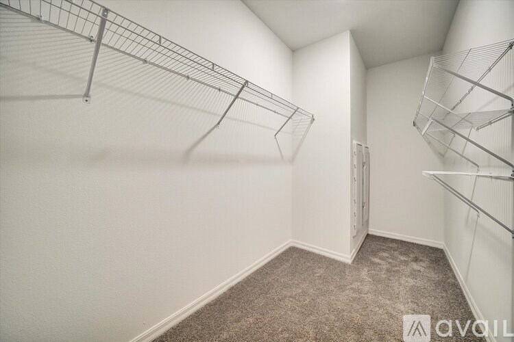 Empty room with wire shelves and carpeted floor.