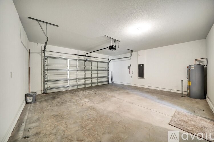 A spacious garage with a roll-up door and a workbench.