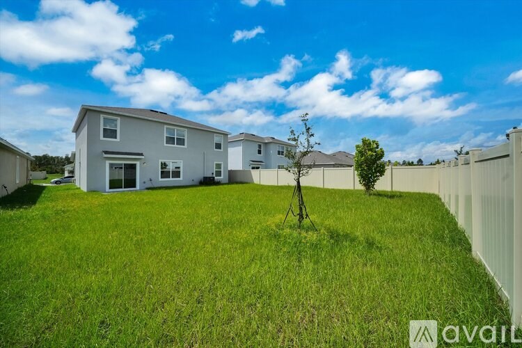 A white house with a green lawn in front of it.