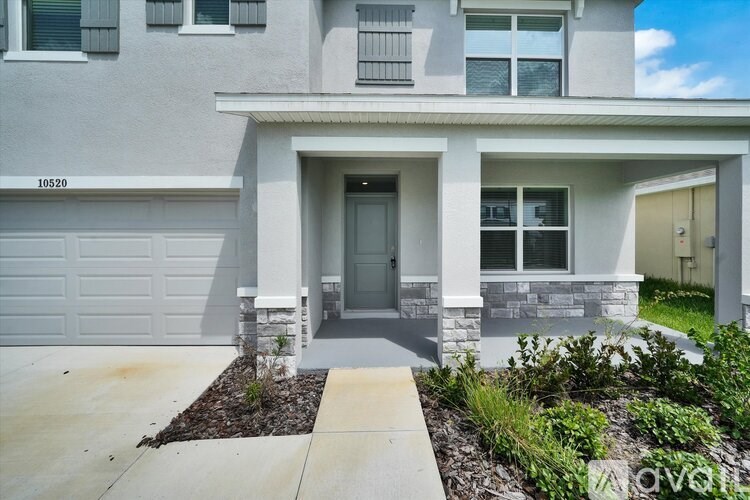 A modern house with a grey facade and a white garage door.