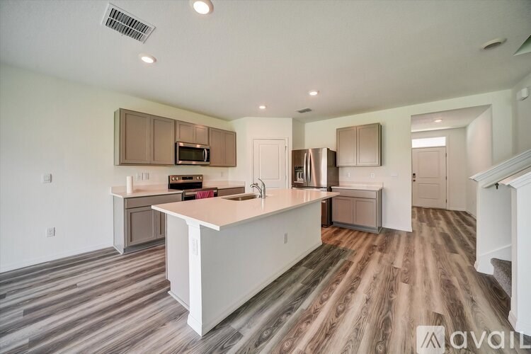 A kitchen with a white island and wooden floors.