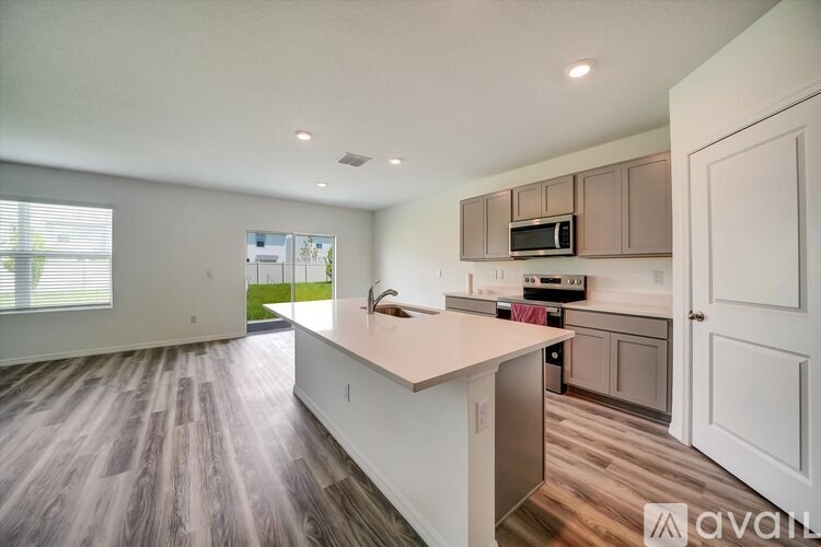 A kitchen with wooden floors and white countertops.