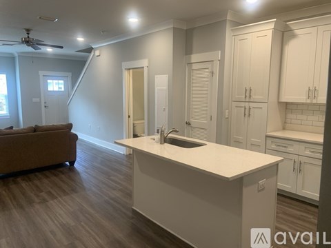 A kitchen with white cabinets and a countertop is available for rent.
