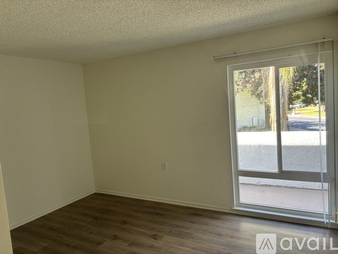 A room with a sliding glass door leading to a street.