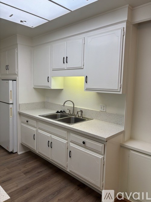 A kitchen with white cabinets and a sink.